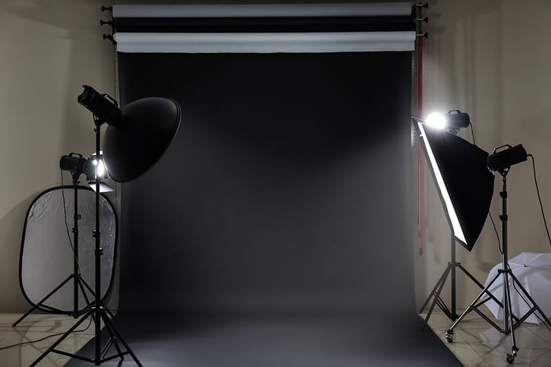 Estudio de fotografía con equipos de iluminación y pantalla negra