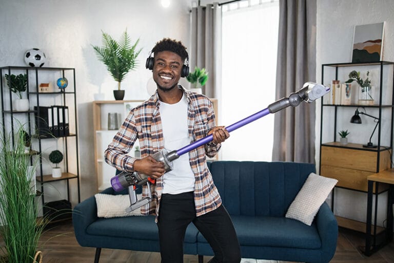 Hombre bailando con una aspiradora durante las tareas