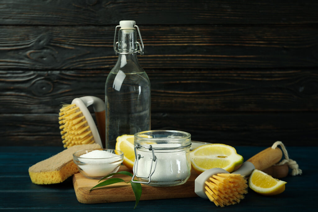 bicarbonato de sodio en un bol , limones y una botella con vinagre para limpieza ecológica